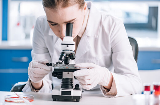 woman looking through microscope